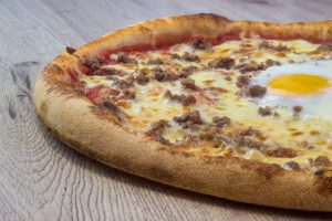 la pizza cannibale, l'authentique pizzeria à nice nord vous la livre - ingrédients Tomate, Mozzarella, Viande Hachée, Oeuf bio